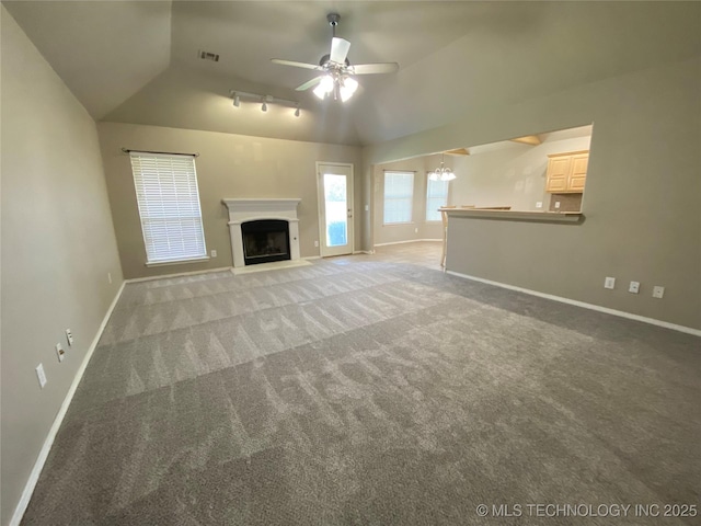 unfurnished living room featuring vaulted ceiling, carpet, and ceiling fan with notable chandelier