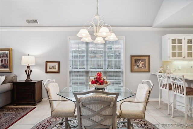 tiled dining area with crown molding, lofted ceiling, and a chandelier