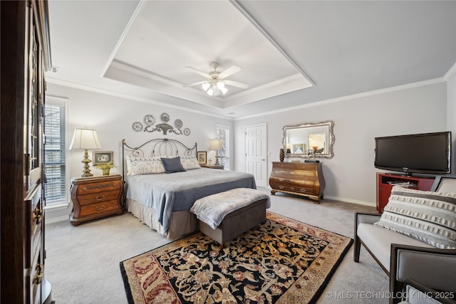 carpeted bedroom featuring ornamental molding, a raised ceiling, and ceiling fan