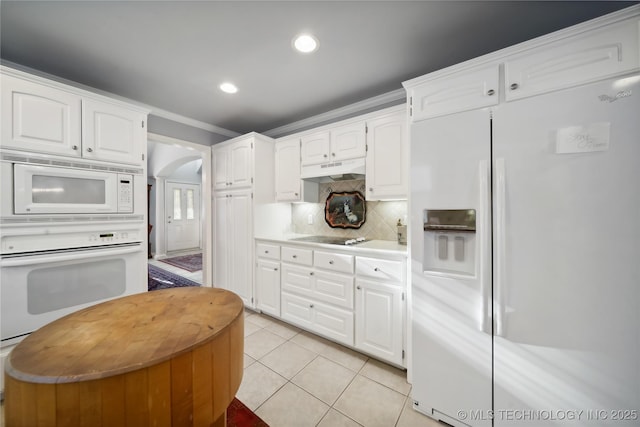 kitchen featuring light tile patterned floors, white appliances, crown molding, tasteful backsplash, and white cabinets