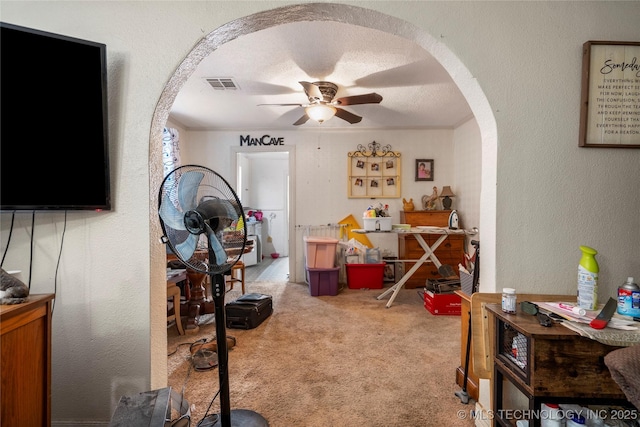 interior space with crown molding, a textured ceiling, light colored carpet, and ceiling fan