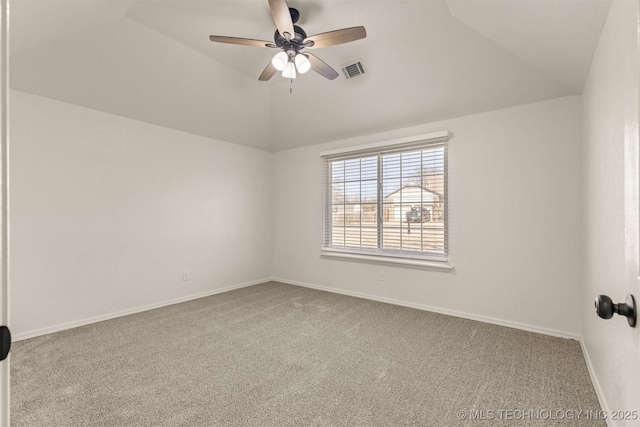 carpeted spare room with ceiling fan, a raised ceiling, and vaulted ceiling