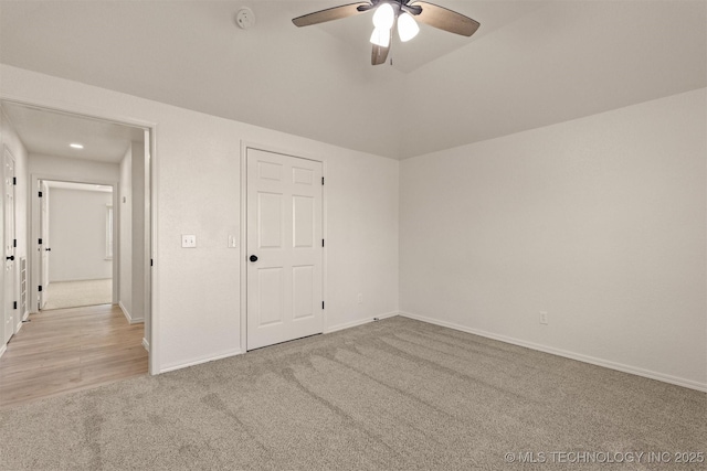 unfurnished bedroom featuring vaulted ceiling, ceiling fan, light colored carpet, and a closet