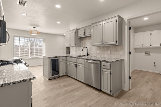 kitchen featuring gray cabinetry, sink, stainless steel appliances, and beverage cooler