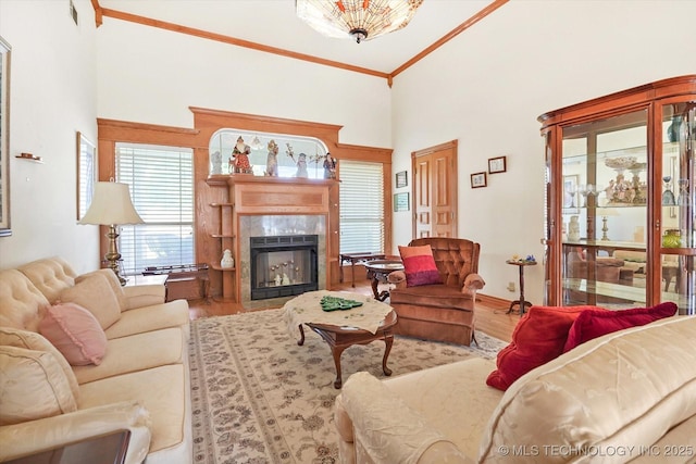 living room featuring ornamental molding, wood-type flooring, a fireplace, and high vaulted ceiling