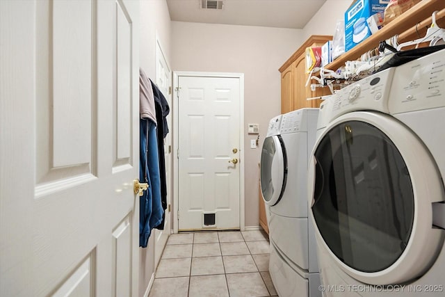 clothes washing area with cabinets, independent washer and dryer, and light tile patterned flooring