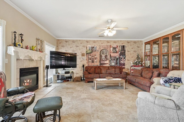 living room featuring a tiled fireplace, ornamental molding, and ceiling fan