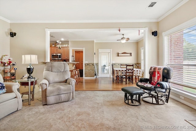 living room with crown molding, light hardwood / wood-style flooring, and ceiling fan