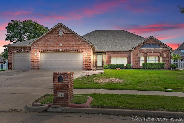 view of front of house with a garage and a lawn