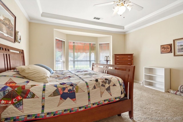 bedroom featuring crown molding, a raised ceiling, ceiling fan, and carpet