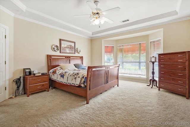 carpeted bedroom featuring crown molding, ceiling fan, and a raised ceiling