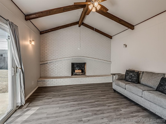 unfurnished living room with ceiling fan, hardwood / wood-style floors, a brick fireplace, and vaulted ceiling with beams