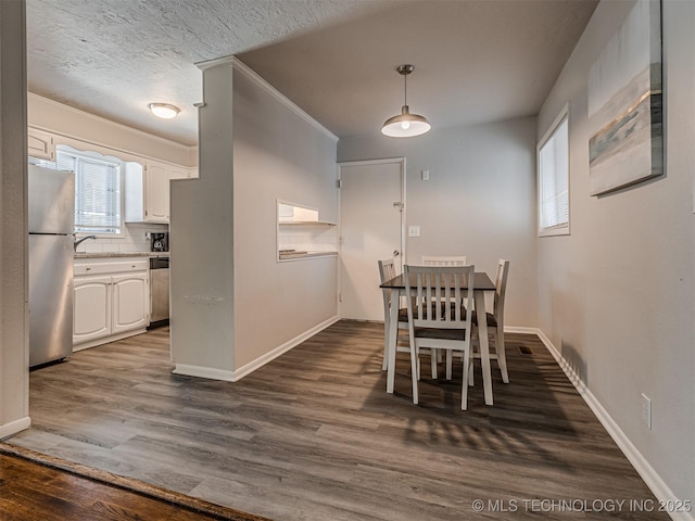 dining room with sink, dark wood-type flooring, and a textured ceiling