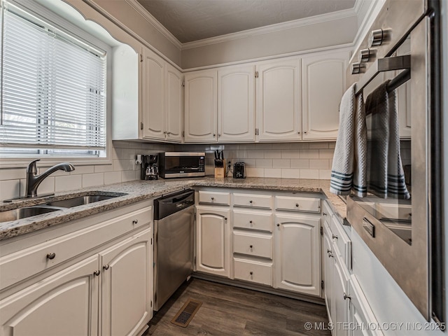 kitchen featuring stainless steel appliances, white cabinetry, sink, and backsplash