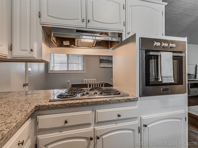 kitchen featuring white cabinetry, stainless steel appliances, and light stone counters