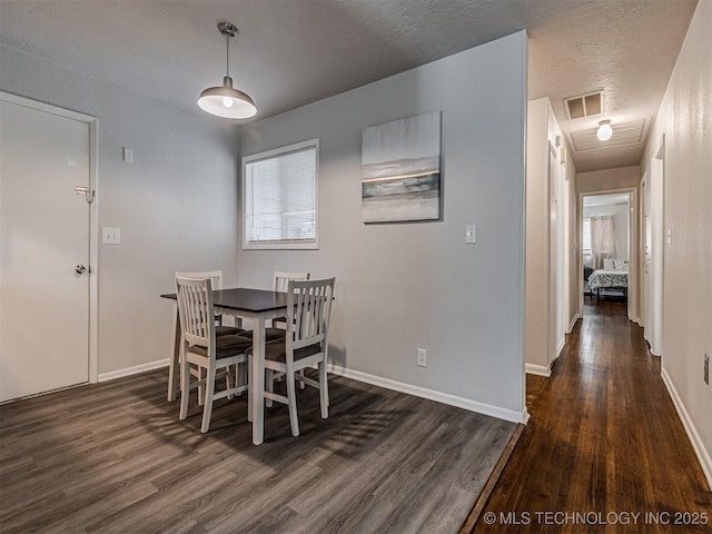 dining area featuring dark hardwood / wood-style floors and a textured ceiling