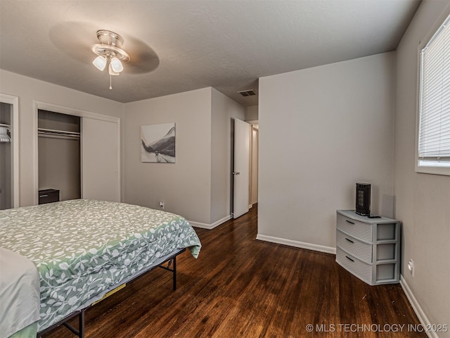 bedroom featuring dark hardwood / wood-style floors, ceiling fan, and a closet