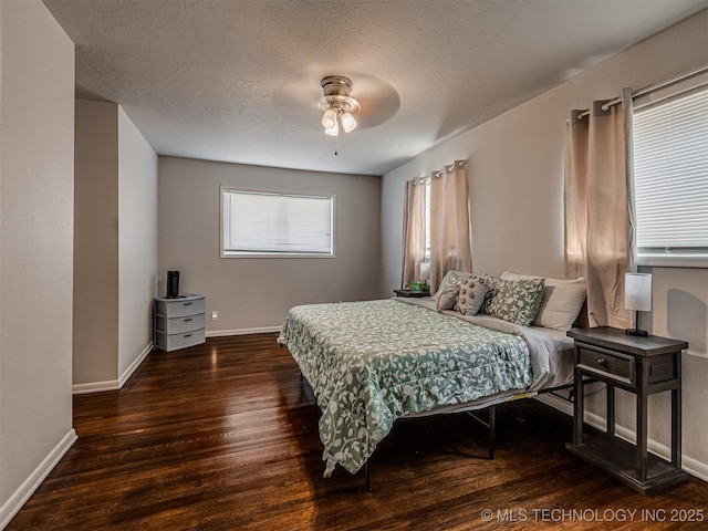 bedroom featuring dark hardwood / wood-style flooring, a textured ceiling, and ceiling fan