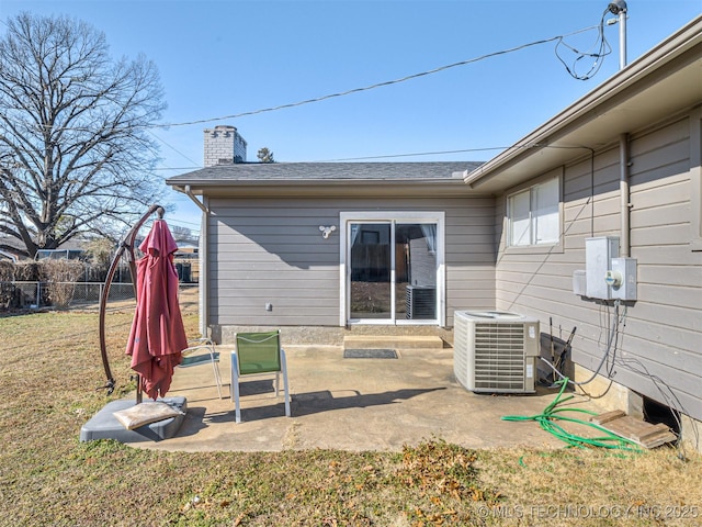 rear view of property featuring a lawn, a patio area, and central air condition unit