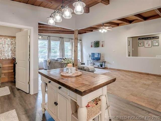 kitchen with wood counters, a center island, hanging light fixtures, wooden ceiling, and beam ceiling