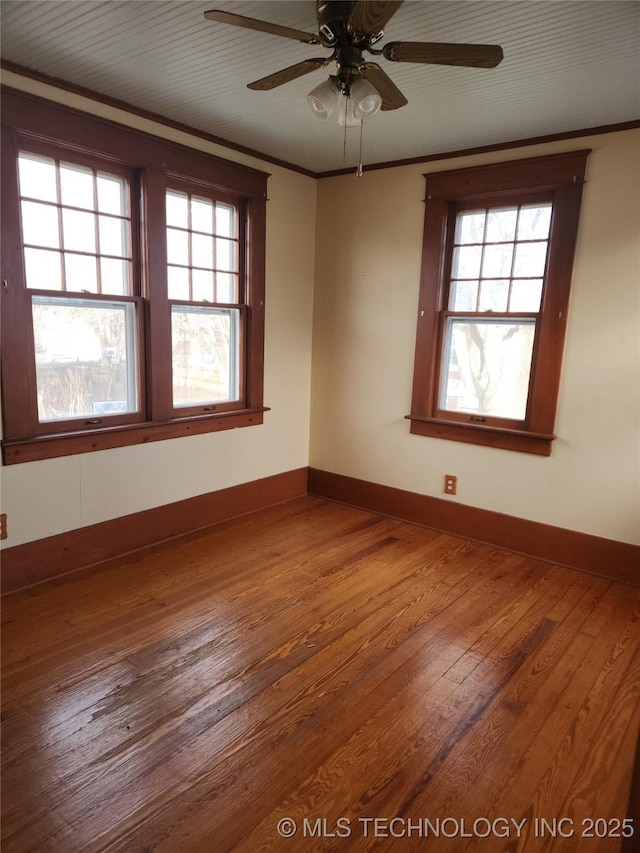 spare room with ceiling fan, crown molding, a wealth of natural light, and wood-type flooring