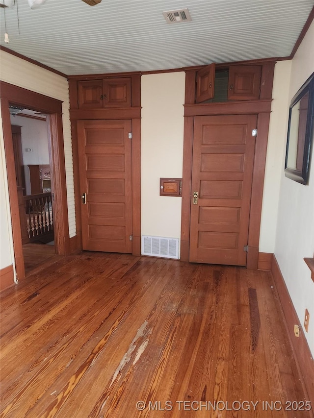 interior space with crown molding and hardwood / wood-style flooring