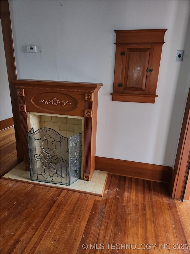 details featuring hardwood / wood-style flooring and a tile fireplace