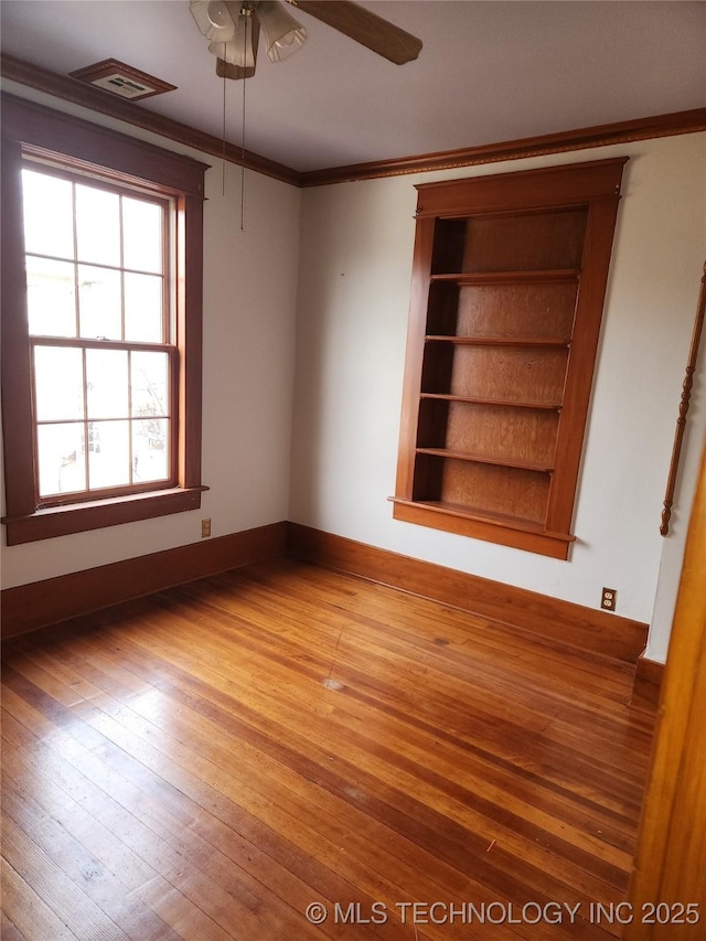 spare room with hardwood / wood-style flooring, ornamental molding, and ceiling fan