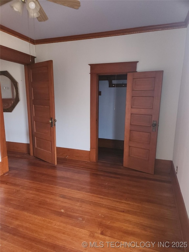 unfurnished bedroom featuring ornamental molding, hardwood / wood-style floors, ceiling fan, and a closet