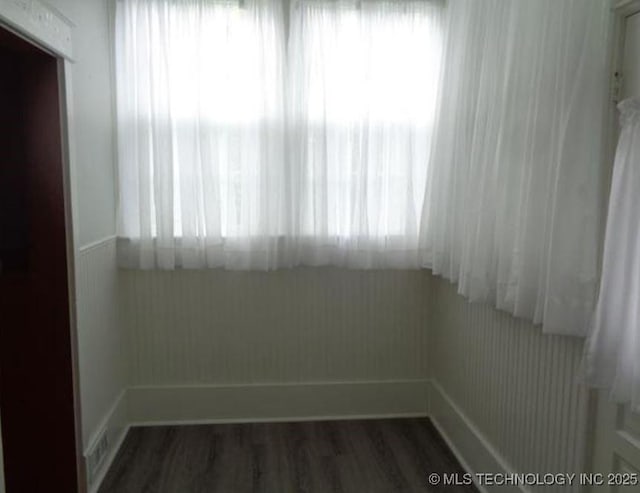 unfurnished room featuring dark hardwood / wood-style floors and a wealth of natural light