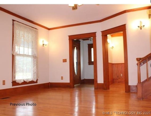 spare room featuring crown molding and hardwood / wood-style floors