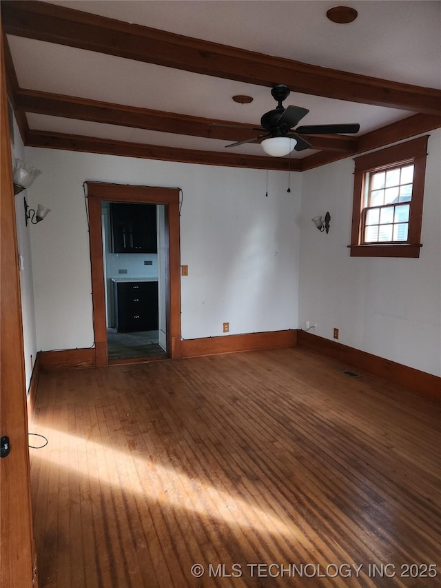 empty room featuring beam ceiling, wood-type flooring, and ceiling fan