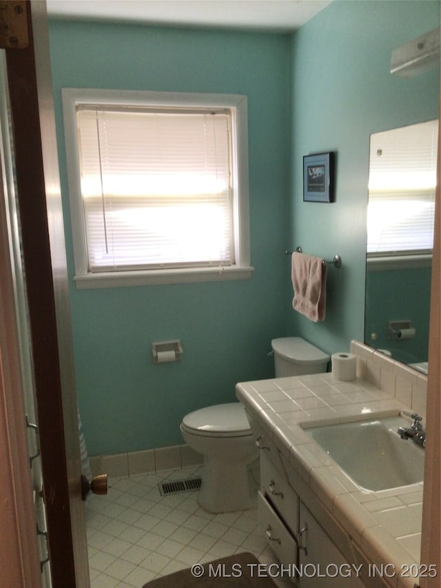 bathroom featuring vanity, tile patterned floors, and toilet