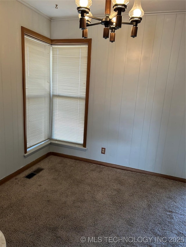 unfurnished room featuring crown molding, carpet floors, and a chandelier