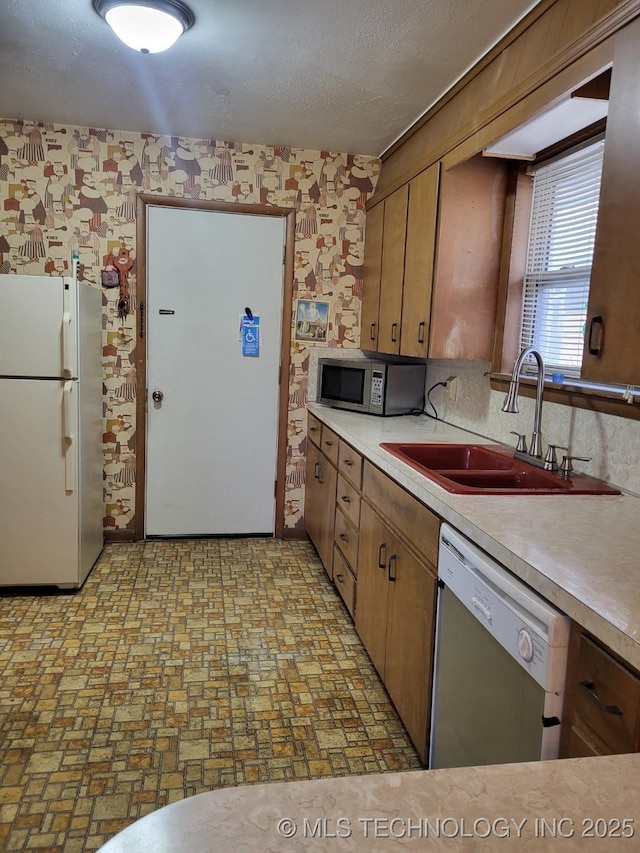 kitchen featuring sink, a textured ceiling, and appliances with stainless steel finishes