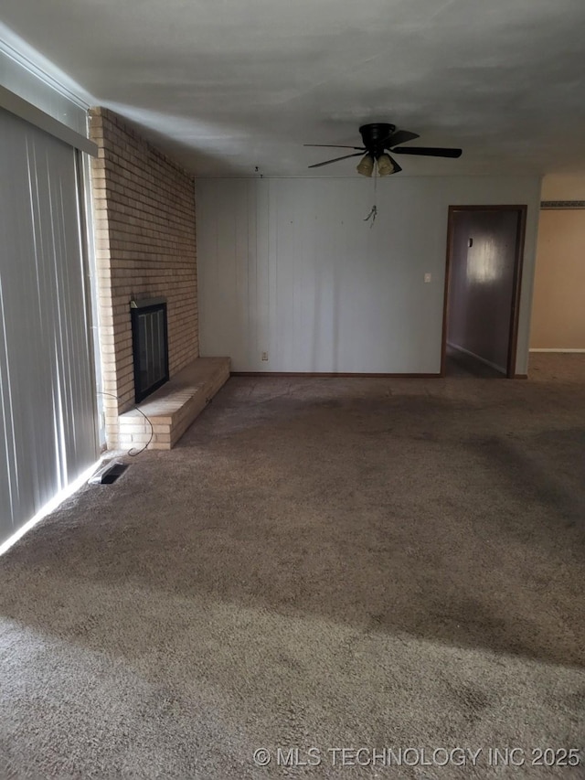 unfurnished living room with carpet, ceiling fan, and a brick fireplace