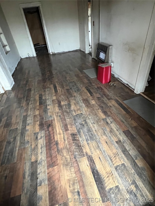 unfurnished living room featuring dark wood-type flooring and heating unit