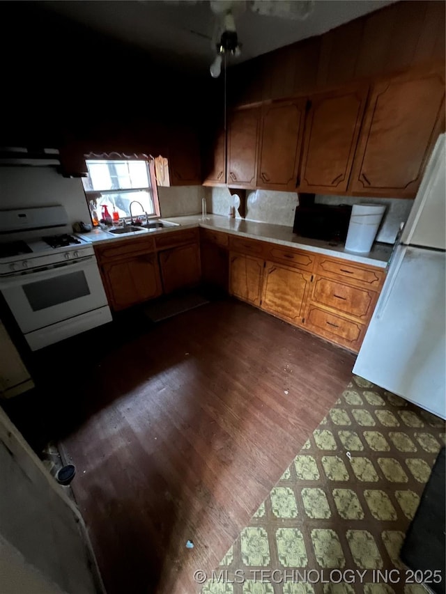 kitchen featuring sink, dark hardwood / wood-style floors, and white gas range oven