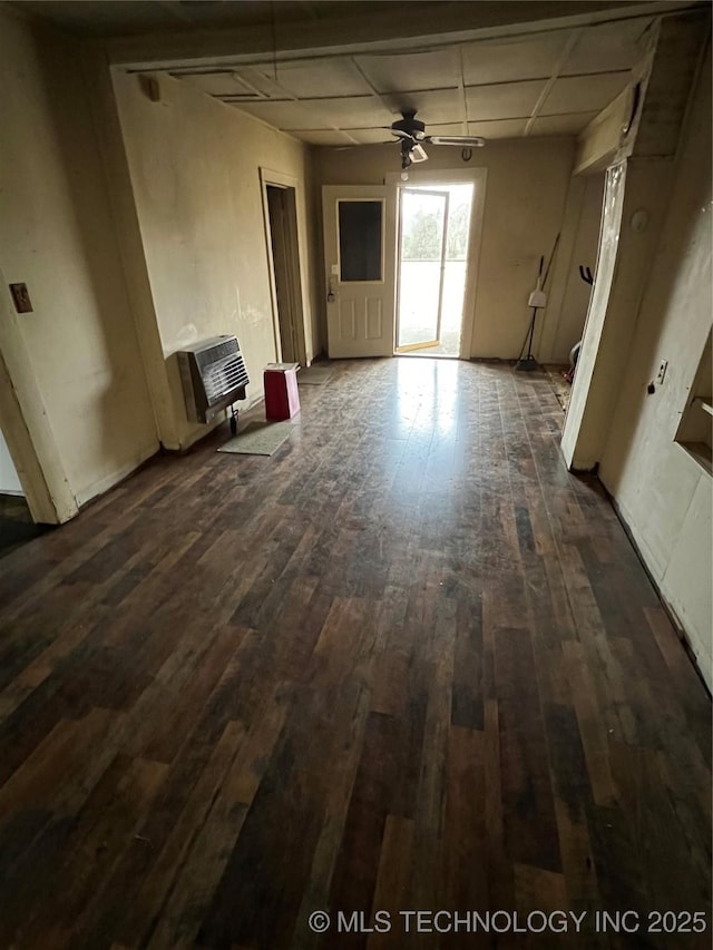 unfurnished living room featuring ceiling fan, dark hardwood / wood-style floors, and heating unit