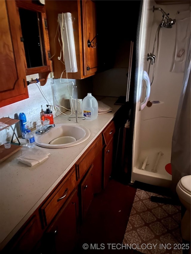 bathroom with vanity, toilet, and a shower