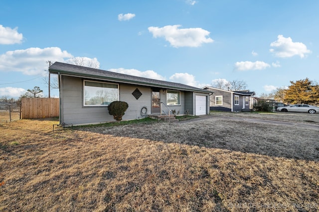 ranch-style house with a garage and a front yard