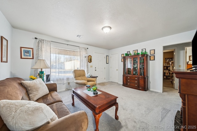 living room featuring light colored carpet and a textured ceiling