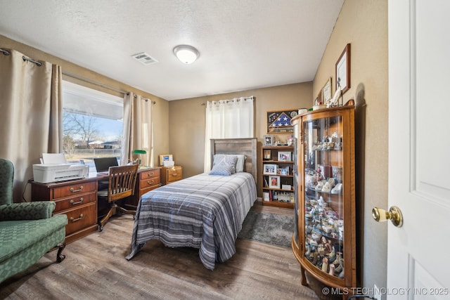 bedroom with hardwood / wood-style flooring and a textured ceiling