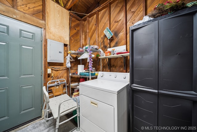 washroom featuring washer / dryer, electric panel, and wood walls