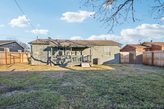 back of property featuring a deck and a lawn