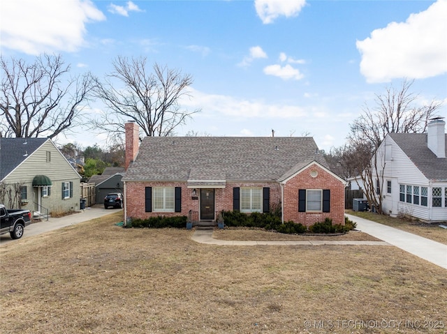 view of front of house with central AC and a front yard