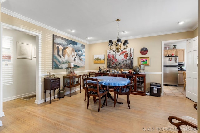 dining room with crown molding, a notable chandelier, and light hardwood / wood-style floors