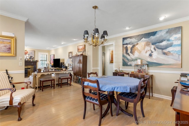 dining area featuring an inviting chandelier, crown molding, and light hardwood / wood-style floors