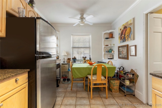 tiled dining room featuring crown molding and ceiling fan