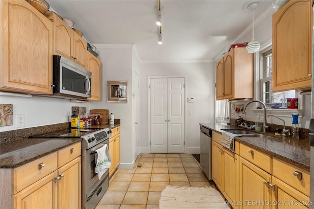 kitchen featuring light tile patterned flooring, appliances with stainless steel finishes, crown molding, and dark stone counters